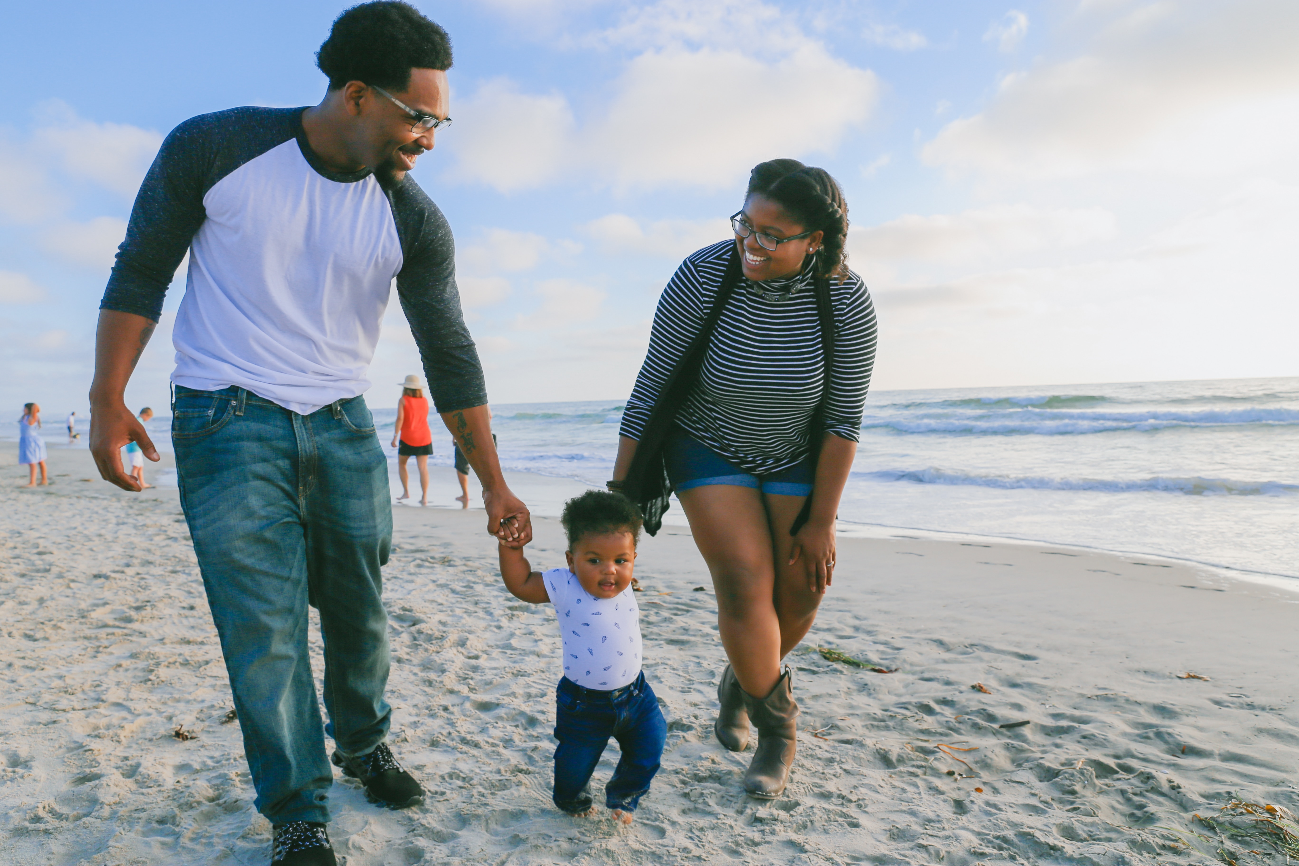 Parents with small child walking on the beach