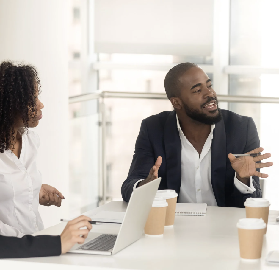 African partners sit and discuss business in an office.