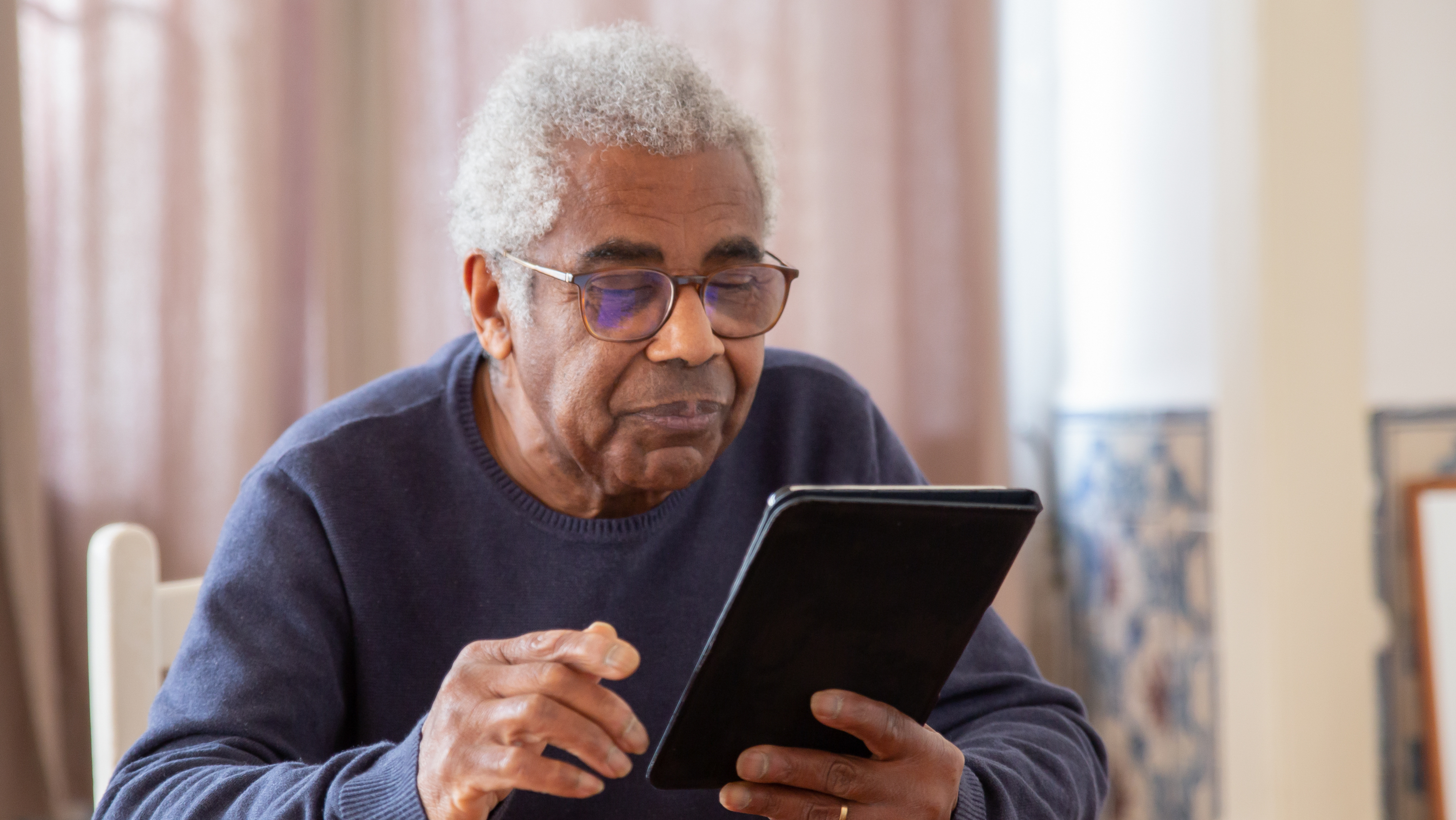 Elderly man searching on tablet