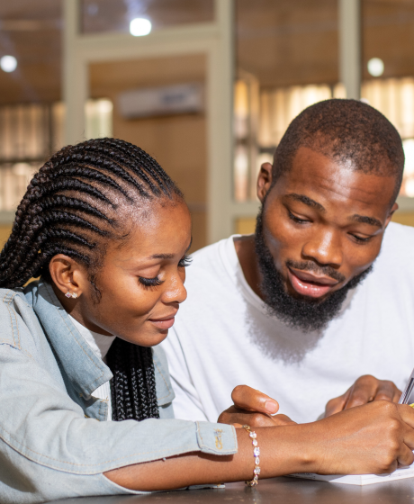 Two Bantwanas sitting at a table going over some documents. 