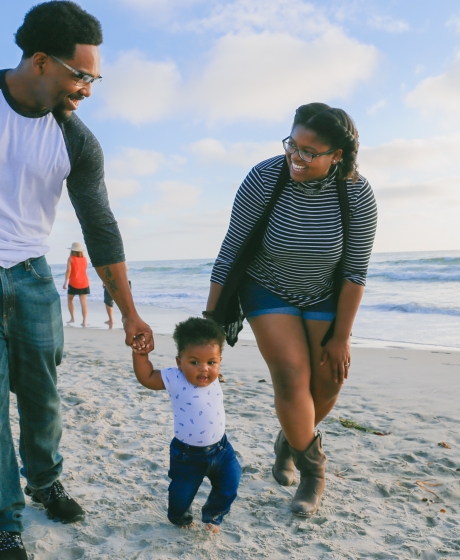 Parents with small child walking on the beach