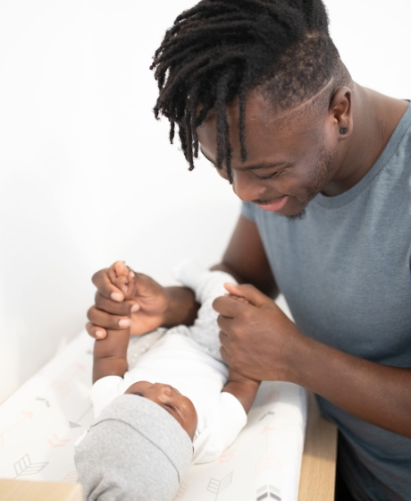 Father with baby child in cot