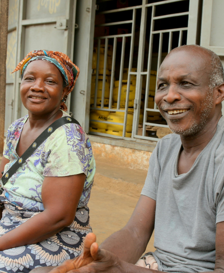 Elderly African couple sits on their patio.