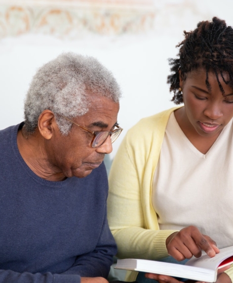 Elderly man with Nurse reading book