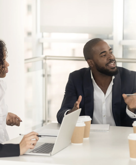 African partners sit and discuss business in an office. 
