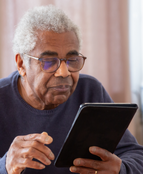 Elderly man searching on tablet